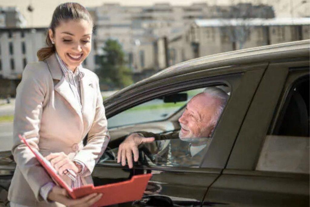 Senior driver smiling while driving, showing the importance of senior car insurance for safety and peace of mind