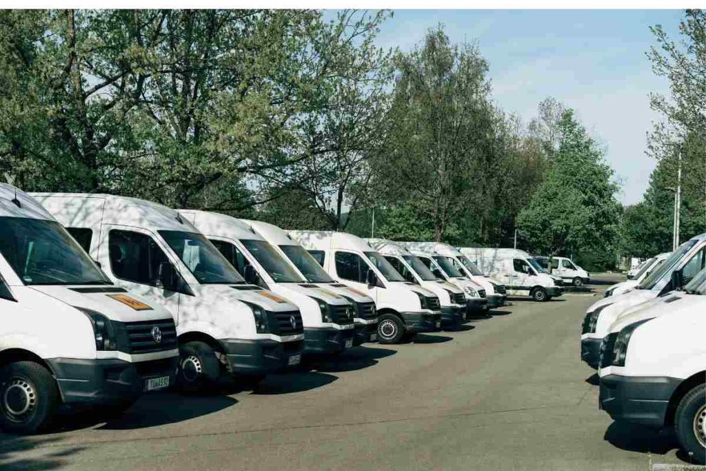 Row of white delivery vans at rest, showing vehicles covered under USAA commercial auto insurance.